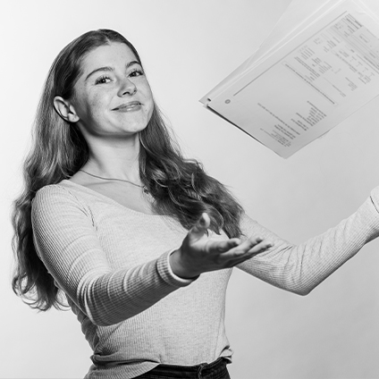 Ein Schwarz-Weiß-Foto einer Frau, die ein Dokument in die Luft würft