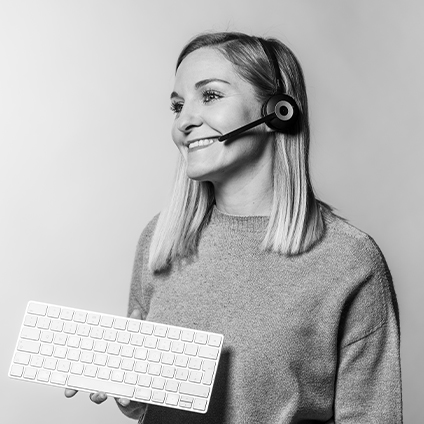 Ein schwarz-weiß Bild einer Frau, die ein Headset trägt und eine Tastatur in der Hand hält